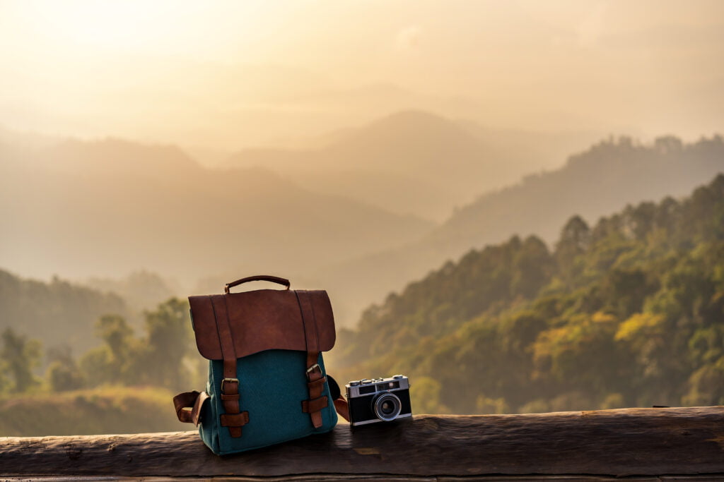 4 Reasons Why Traveling Is Important For Mental Health 5 Travel Backpack And Retro Camera With Landscape Vi 2023 11 27 05 34 40 Utc