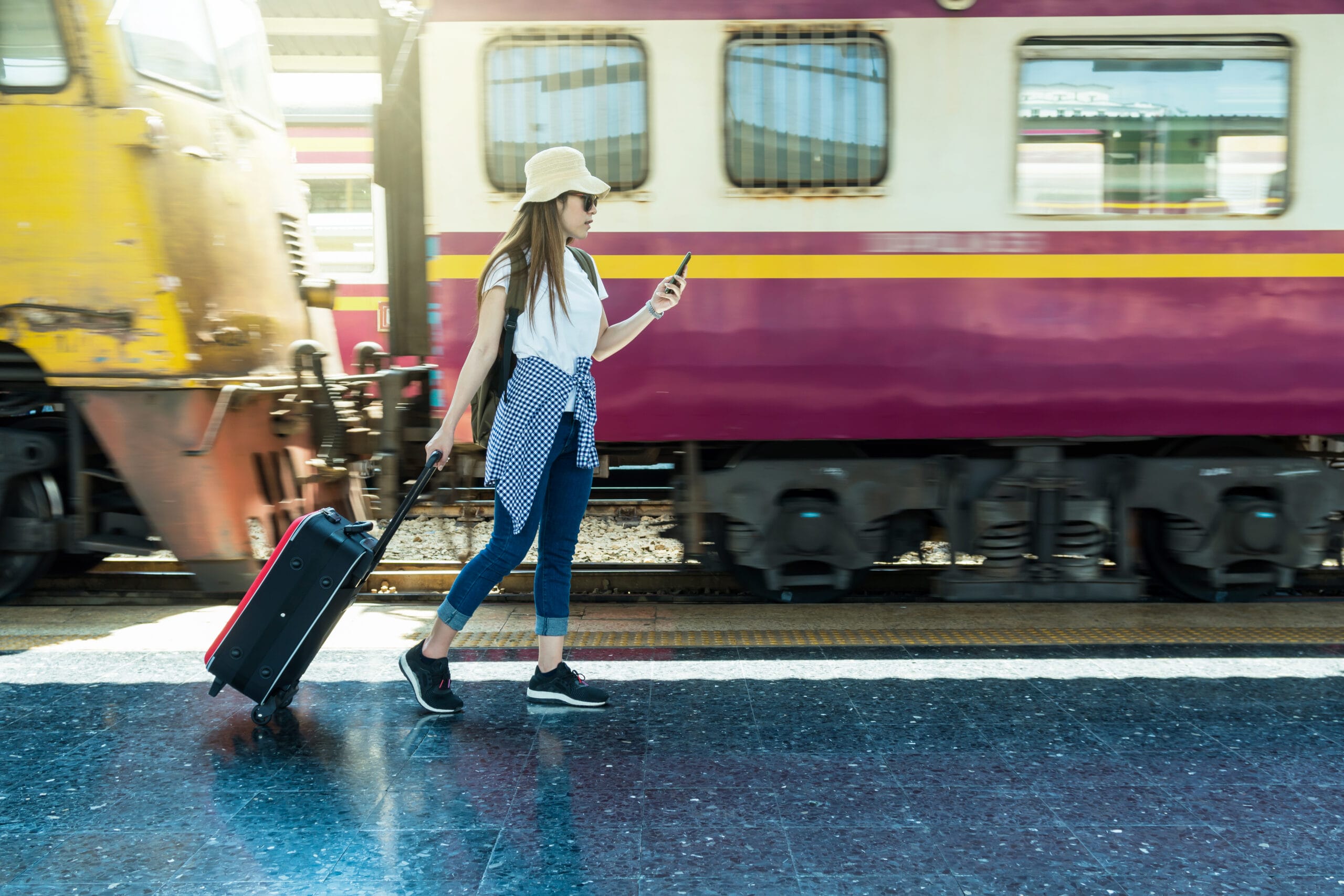 Asia woman Traveller walking and Towing the luggage over the mot Acceptance Path Counseling A traveler with luggage at a train station representing a value driven departure and explaining why travel is good for your mental health when intentional