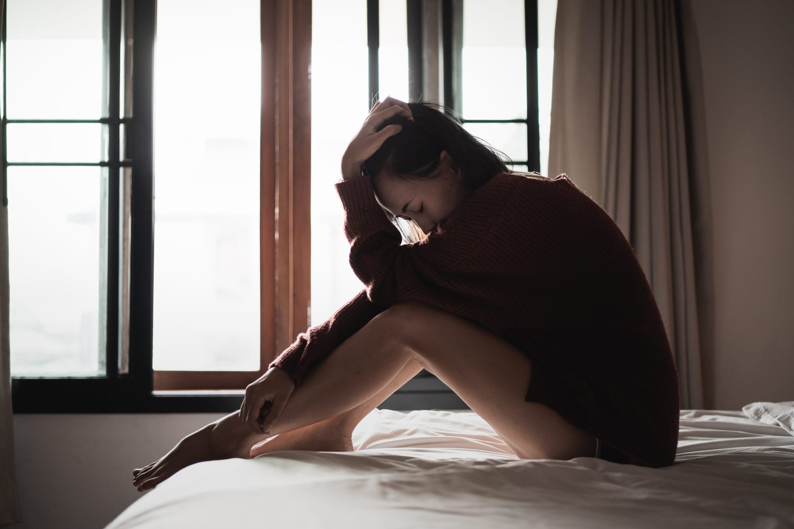 Woman experiencing the physical symptoms of the body's trauma response, demonstrating why learning how to heal from trauma requires more than cognitive insight