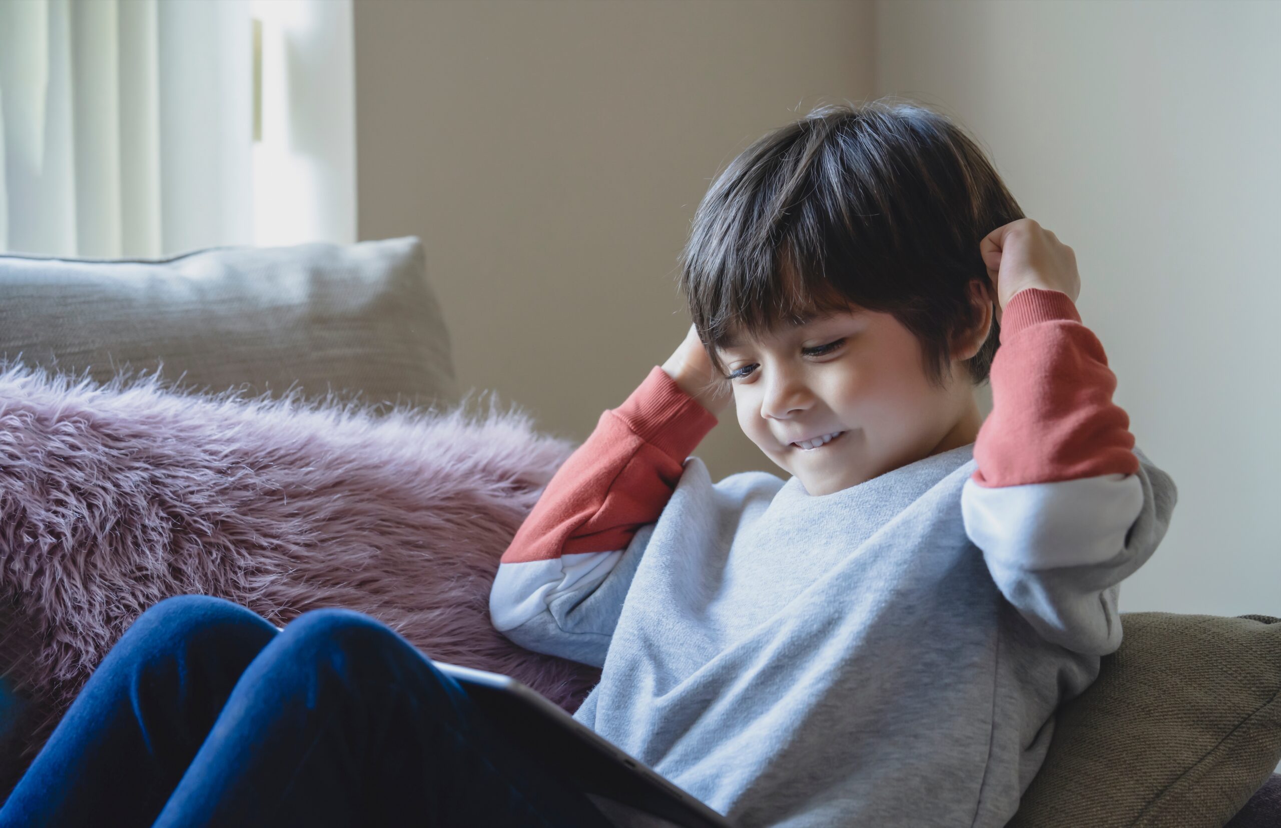 A child concentration focused on building a structure with wooden blocks on a rug in The Woodlands This picture highlights sensory friendly toys and how to help a child with adhd improve their attention span