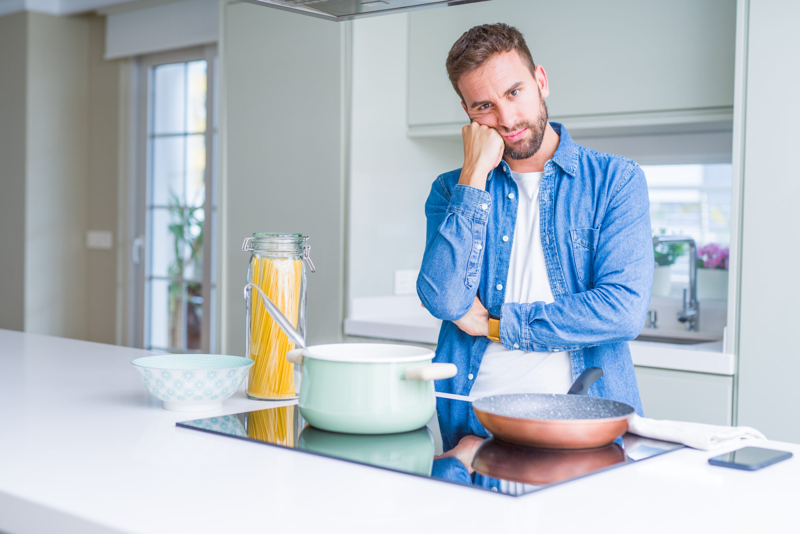 A man in Greenwood Forest pausing mid task in the kitchen with a troubled expression reflecting the distress  not danger  that defines harm OCD the distinction addressed at Acceptance Path Counseling