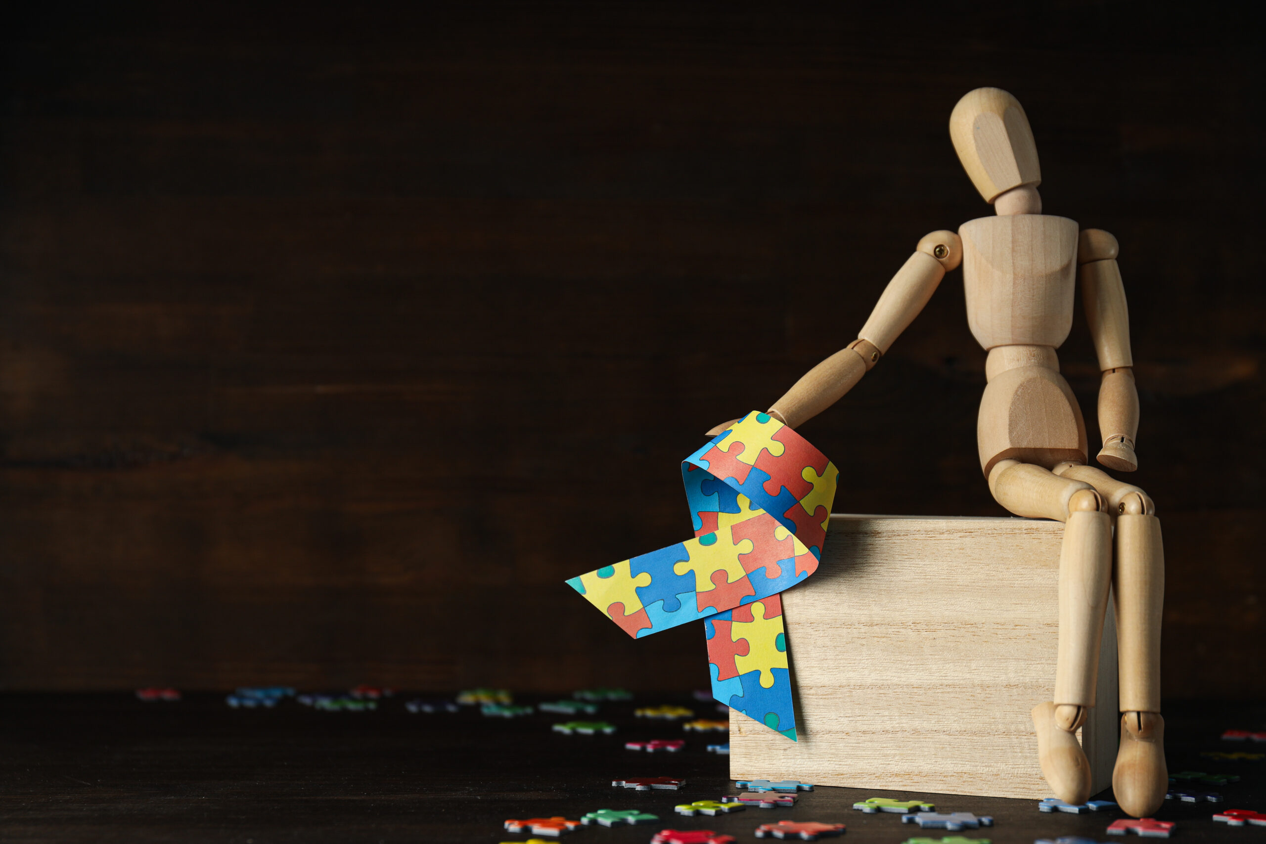A wooden mannequin sits next to an awareness ribbon and scattered puzzle pieces This conceptual visual highlights the clinical complexity of managing adhd and ocd together