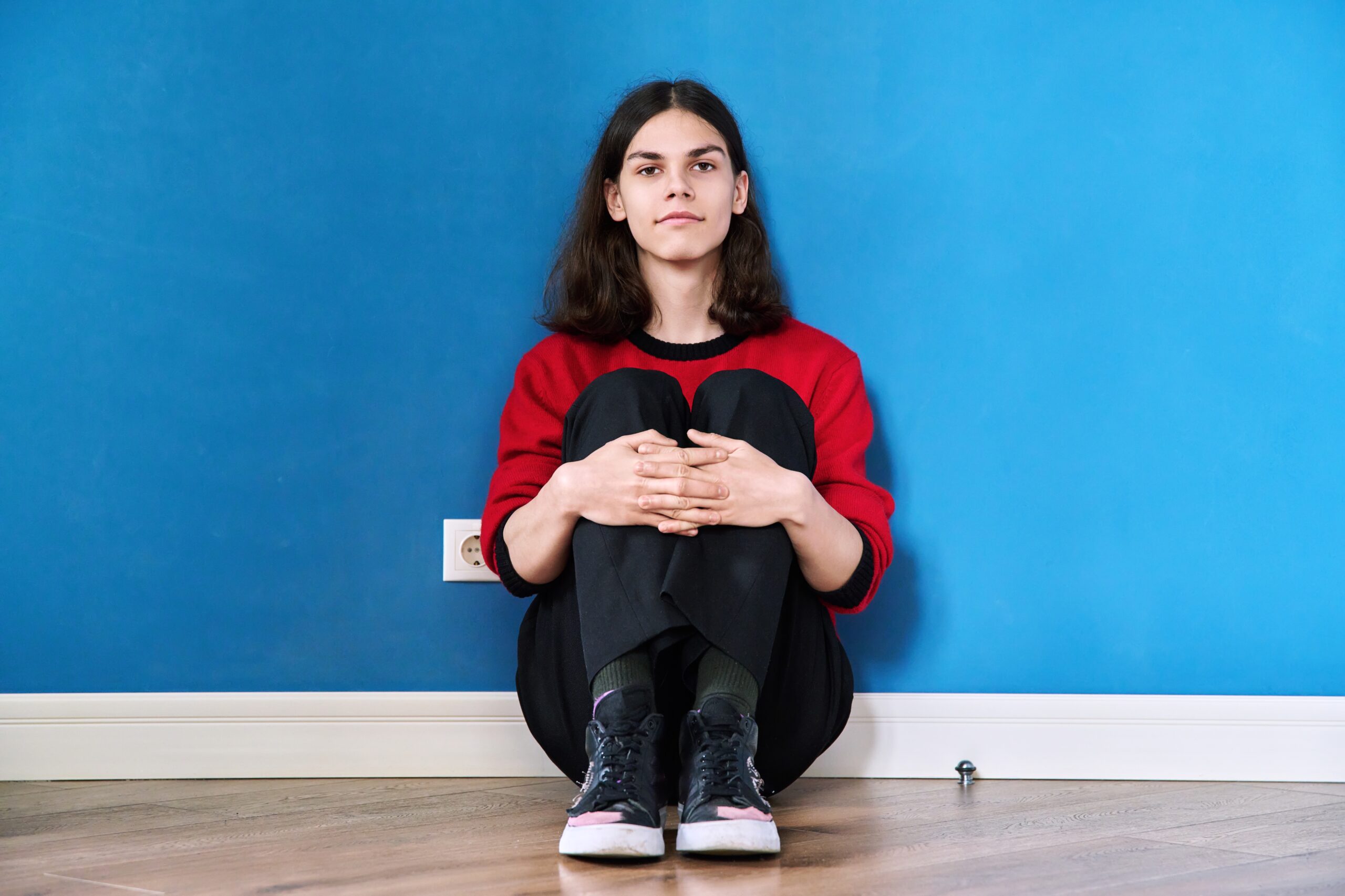 An individual curls up on the floor as multiple surrounding hands point at them This scene visualizes the feelings of judgment and shame experienced with contamination phobia