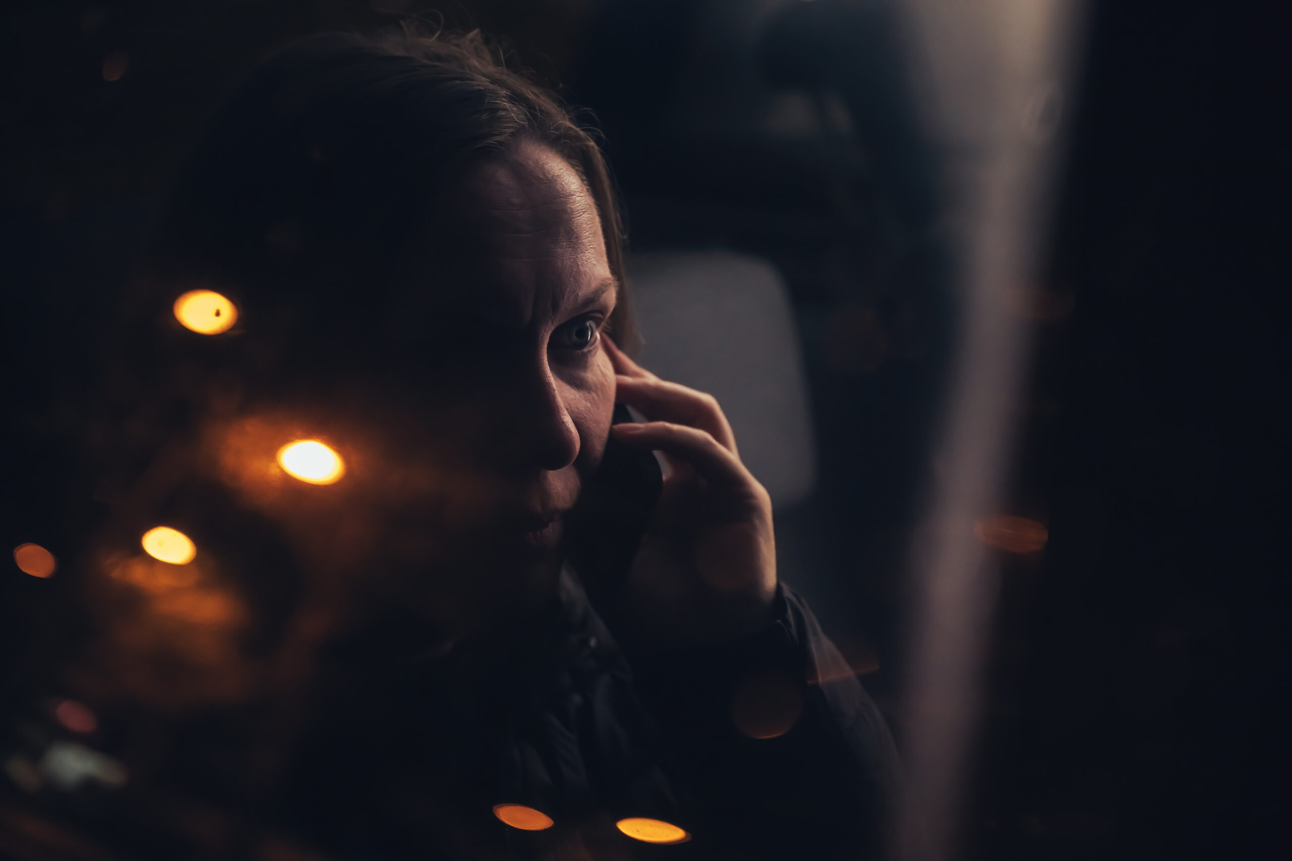 A woman in Kohrville on the phone late at night with a searching urgent expression  capturing the confession cycle of moral scrupulosity OCD that demands reassurance again and again without lasting relief addressed at Acceptance Path Counseling