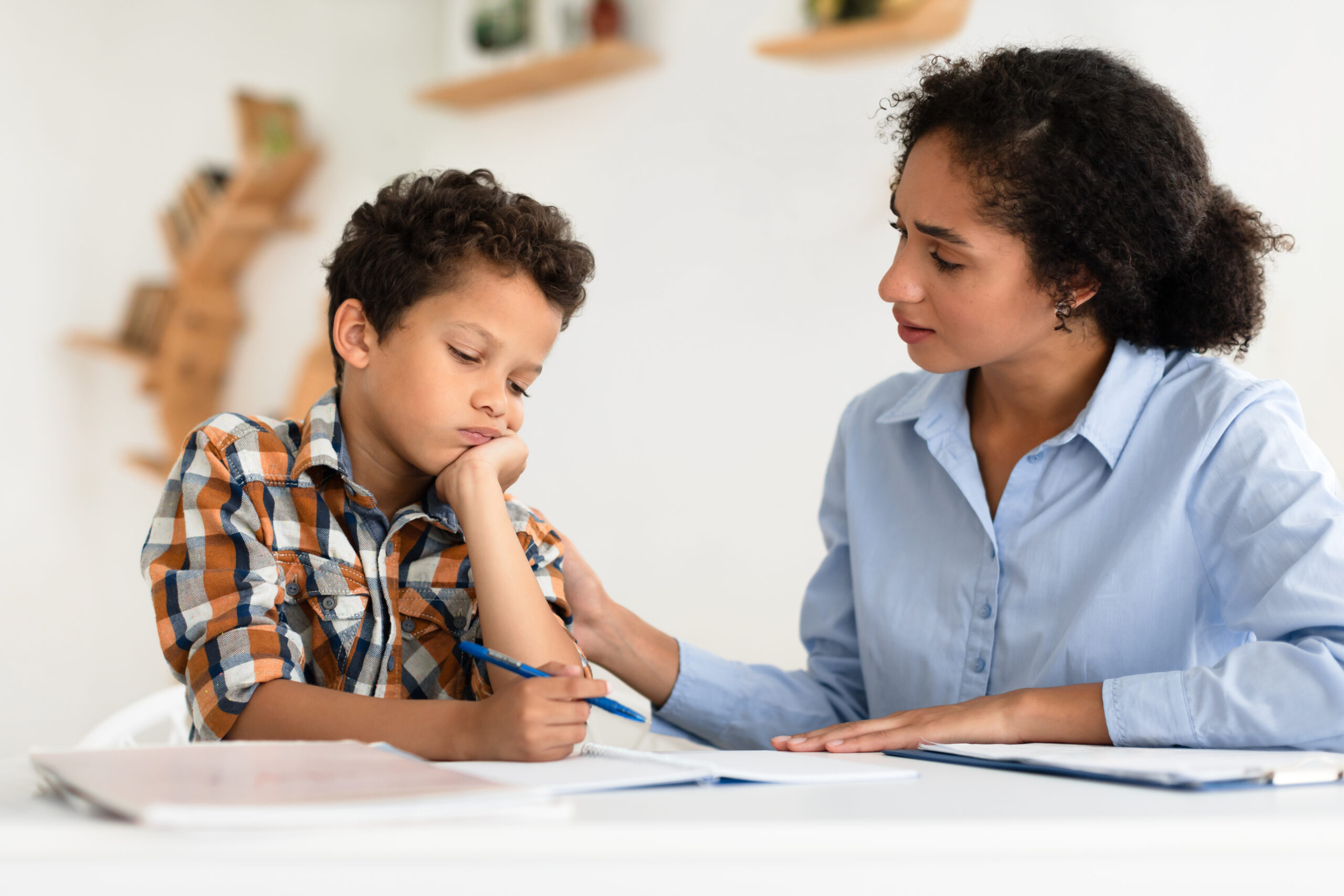A mother points to a visual schedule while talking to her smiling son in their The Woodlands home The image illustrates behavioral strategies and how to help a child with adhd follow daily directions