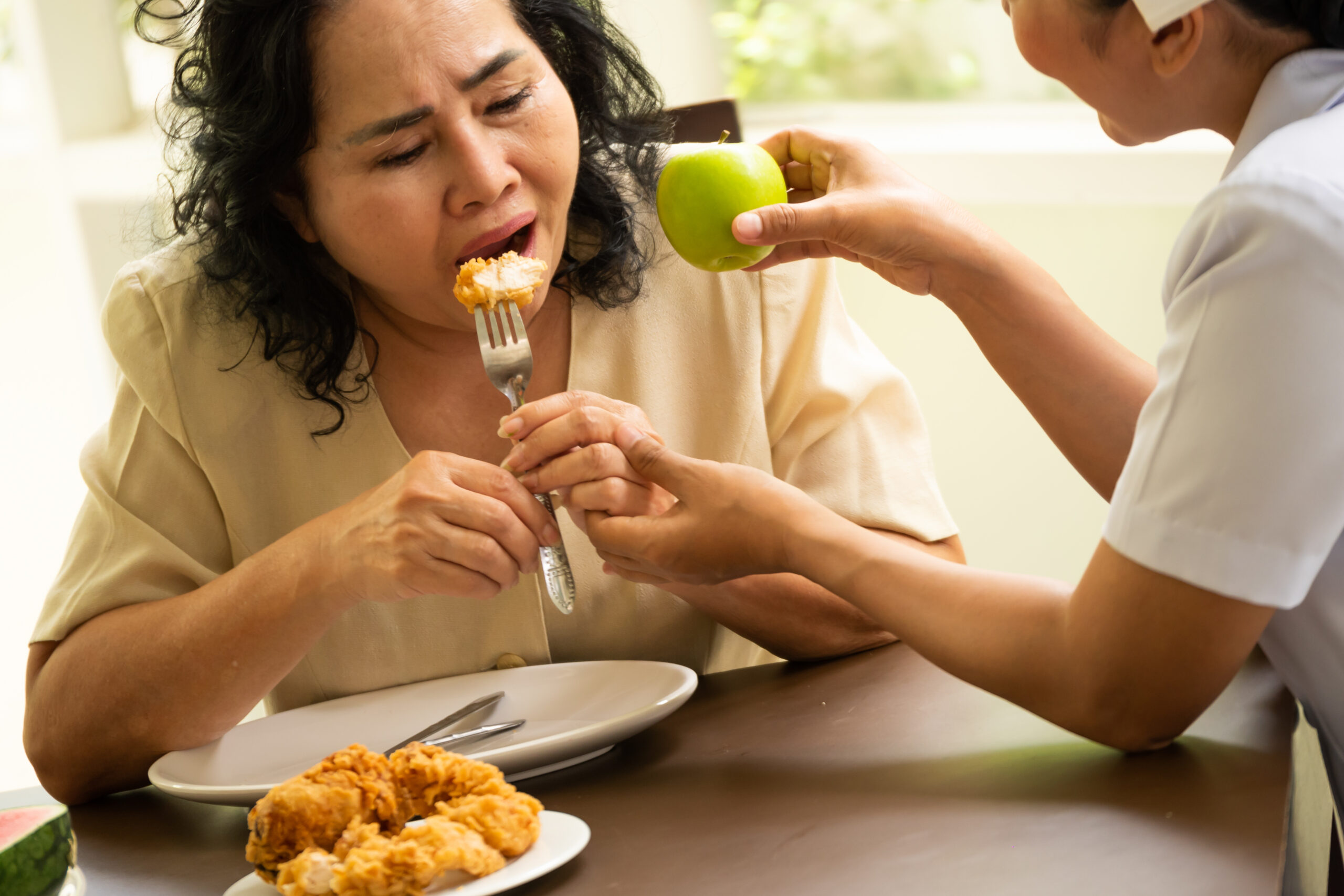 Nurse suggesting adult female patient to eat apple instead of ch Acceptance Path Counseling Guidance on helping a loved one with an eating disorder in a caring and safe way