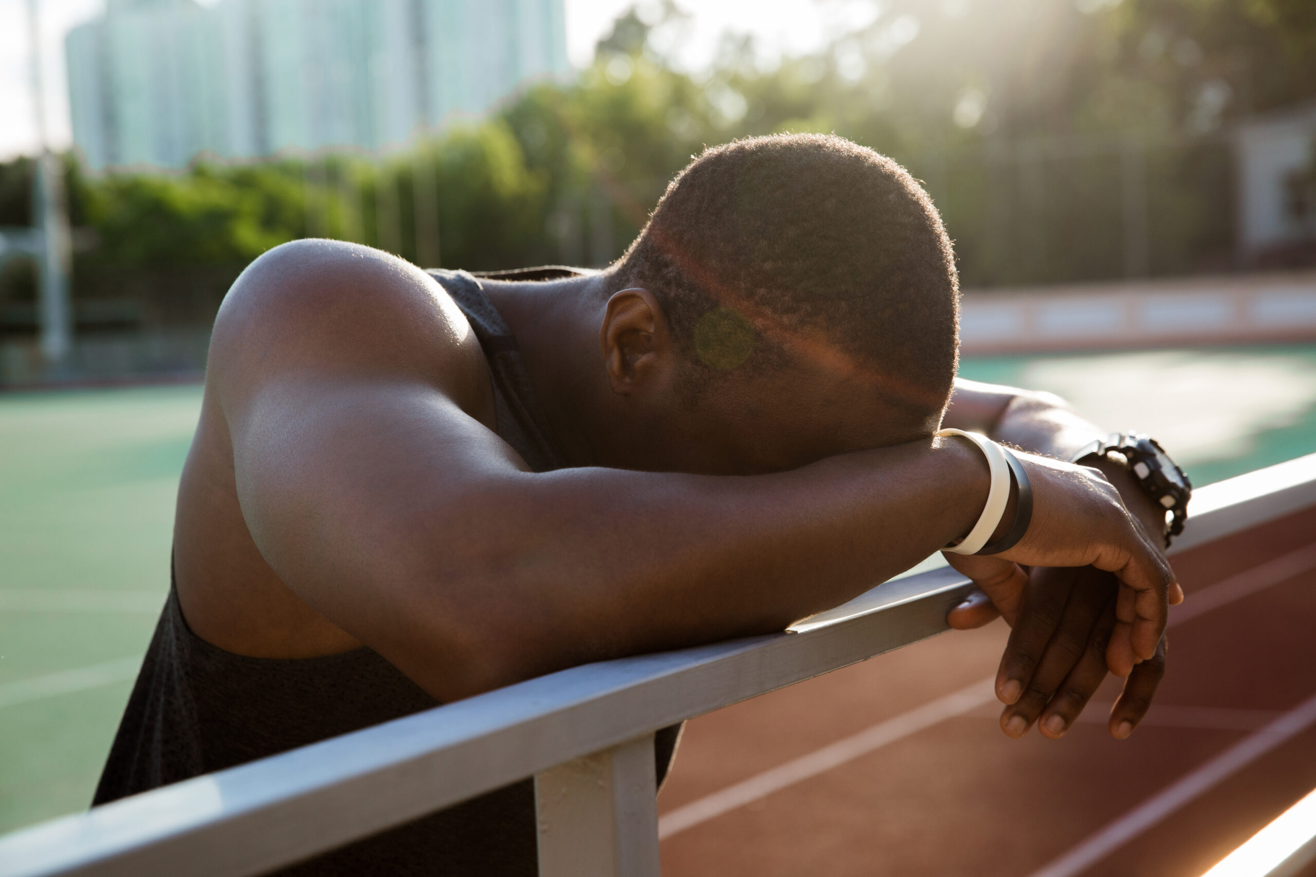 closeupofatiredafricansportsmanleaningont20260326011844utc Acceptance Path Counseling Person taking a quiet moment to cope with depression and fatigue during recovery