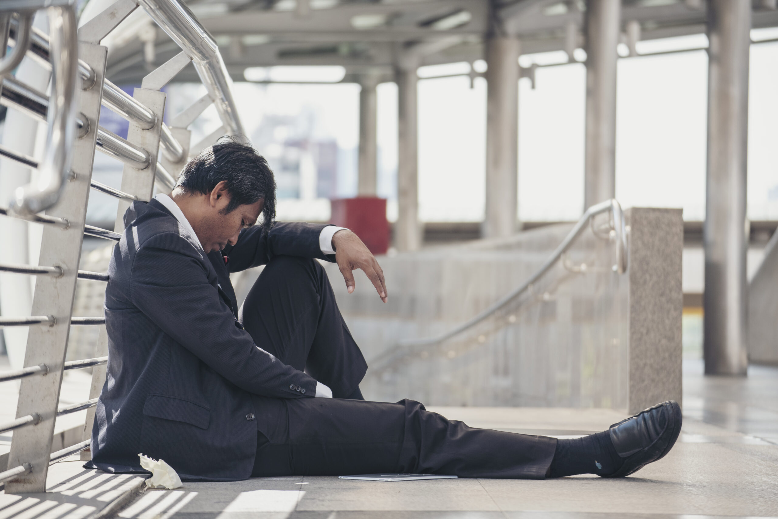 distressedbusinessmansittingonthegroundinan20260615192026utc Acceptance Path Counseling Individual feeling physically exhausted due to depression and fatigue