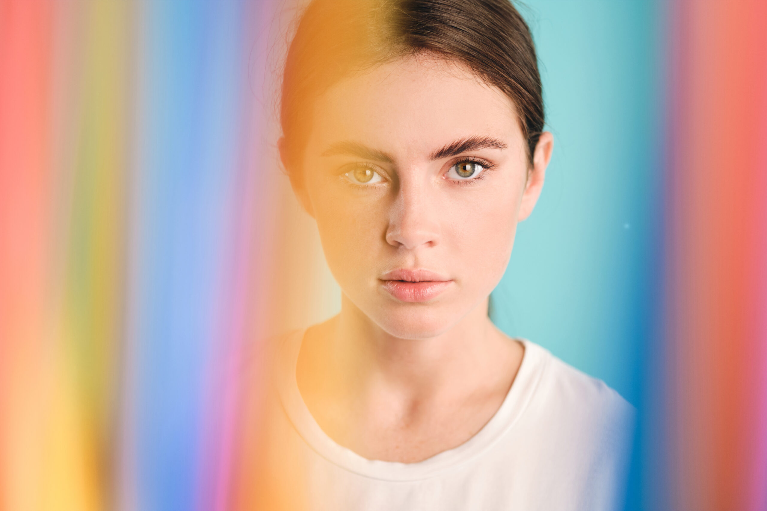 Serious girl thoughtfully looking in camera through colorful pla Acceptance Path Counseling Individual reflecting on self image and relationship challenges while understanding BPD