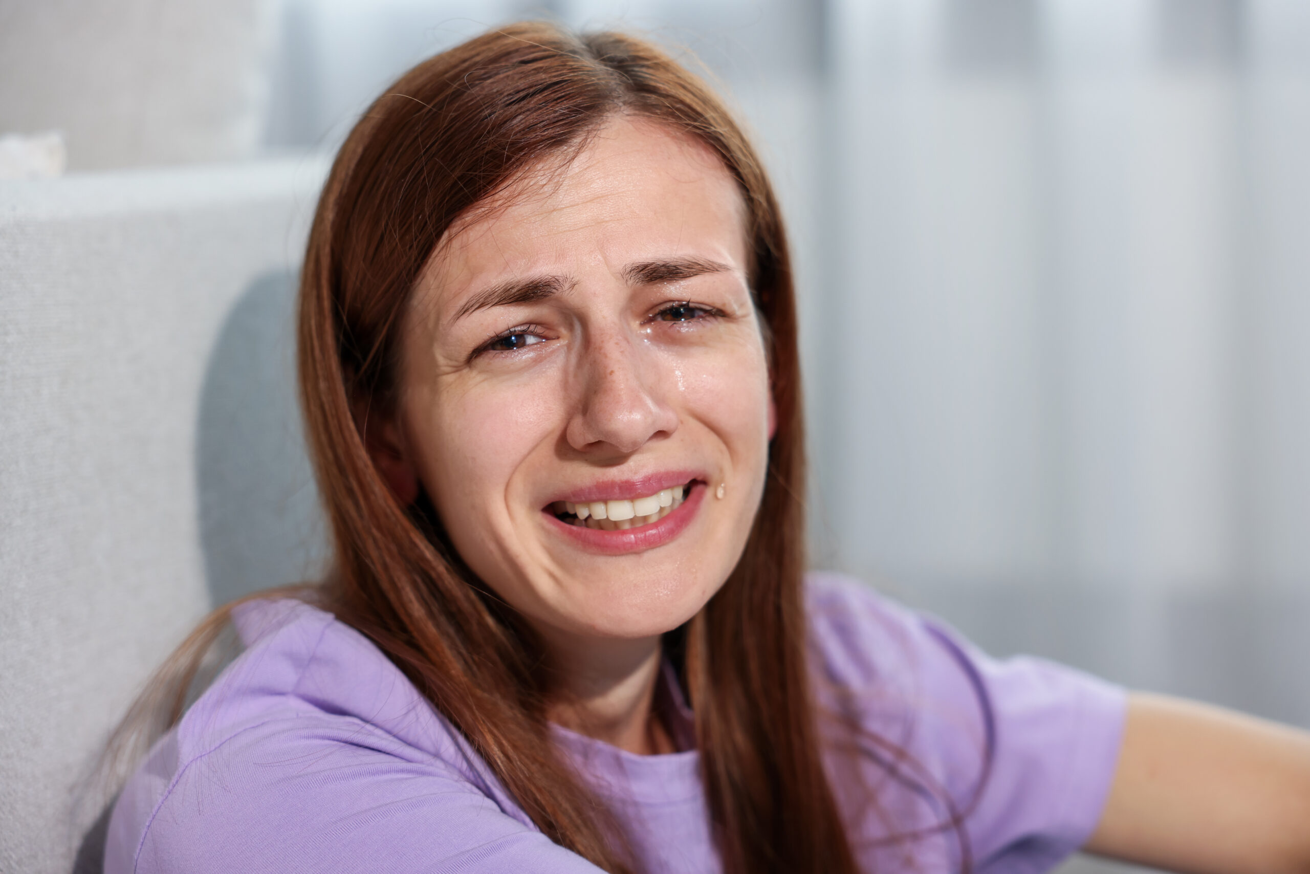 Person appearing cheerful at work while privately experiencing signs of smiling depression