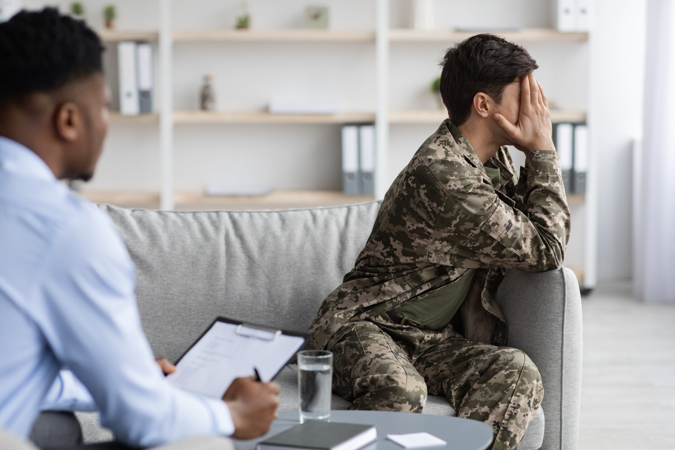 Upset man in camouflage crying while having conversation with psychologist Acceptance Path Counseling Illustration showing how PTSD triggers can cause emotional and physical distress