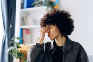 Young woman suffering from strong headache at home Acceptance Path Counseling Illustration of anxiety and overthinking affecting focus and daily decision making
