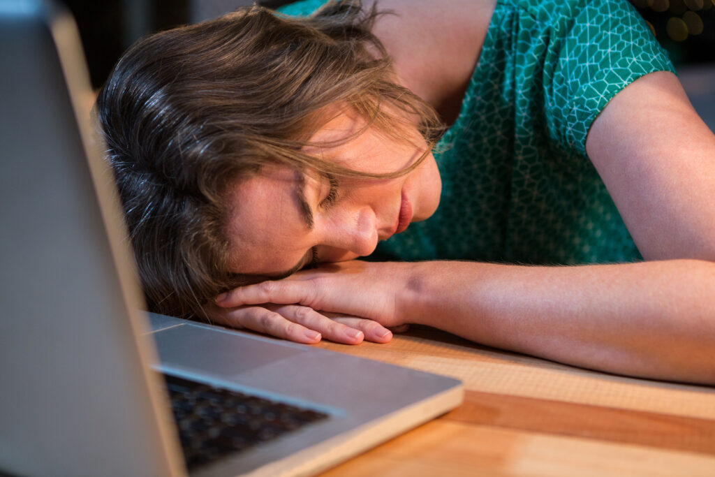 Adult experiencing ADHD burnout while feeling mentally exhausted at a desk