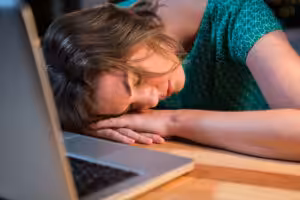 Acceptance Path Counseling Adult experiencing ADHD burnout while feeling mentally exhausted at a desk