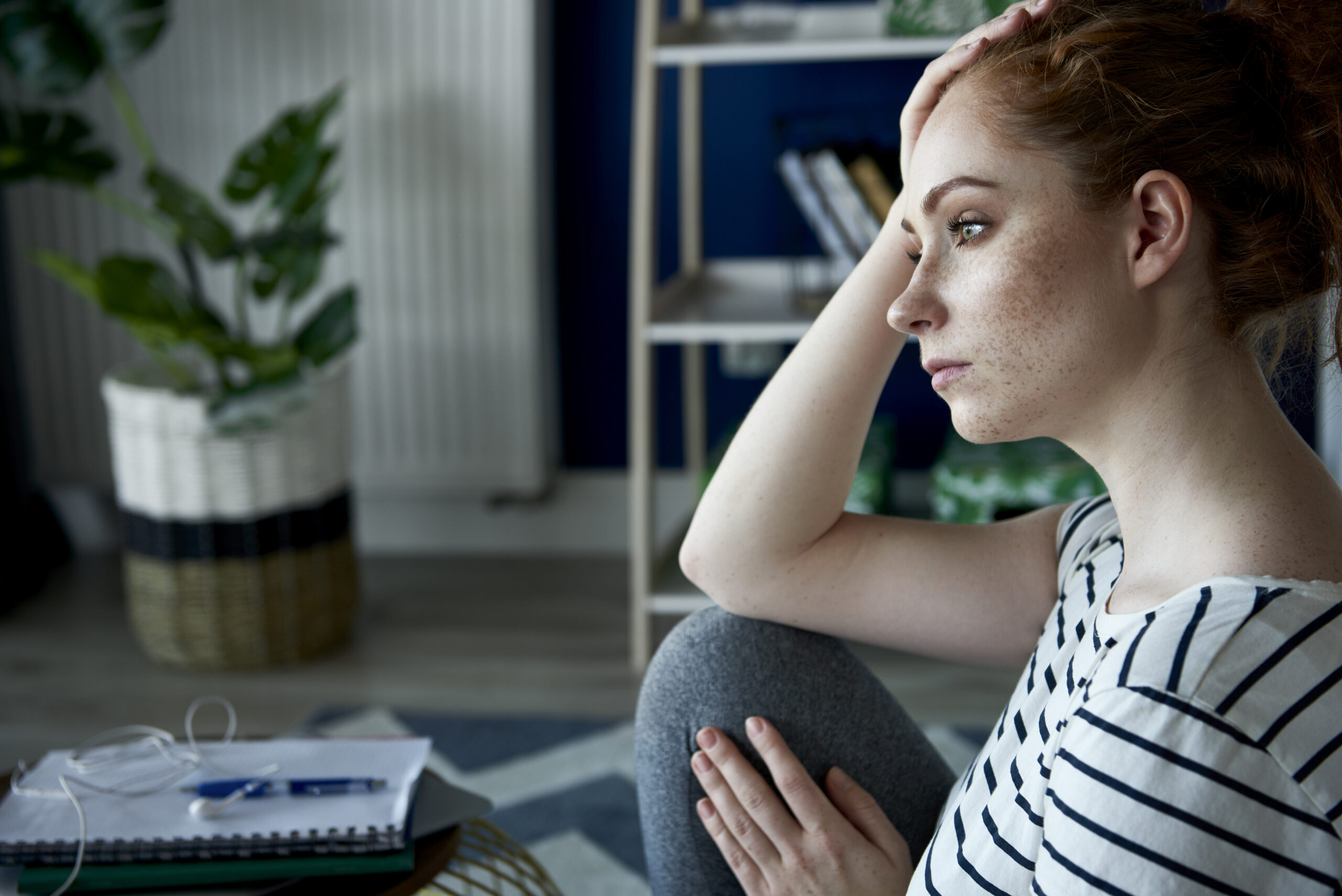 Thoughtful redhead woman in her home Acceptance Path Counseling Person experiencing anxiety and overthinking while sitting alone with racing thoughts
