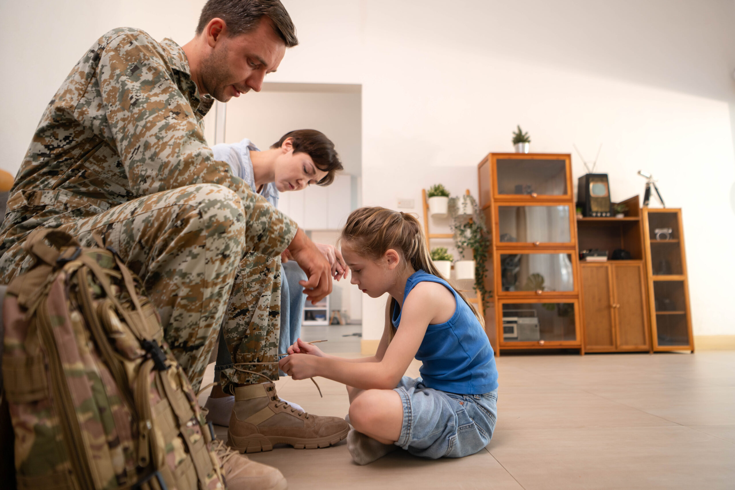 Daughter tying her soldier fathers boots capturing a tender mo Acceptance Path Counseling Mental health illustration representing PTSD triggers and the impact of past trauma
