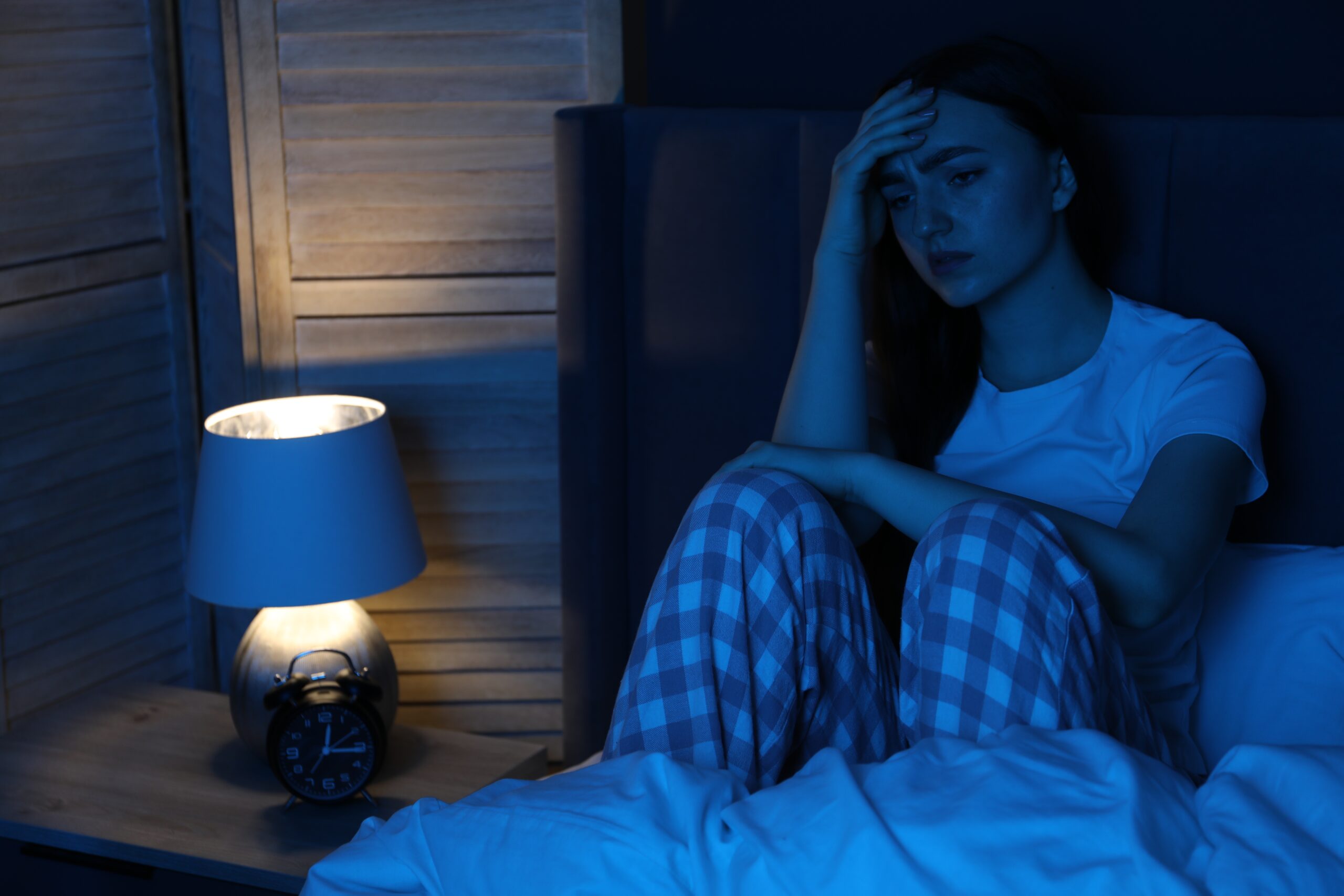 Adult struggling with racing thoughts and nighttime worry before sleep