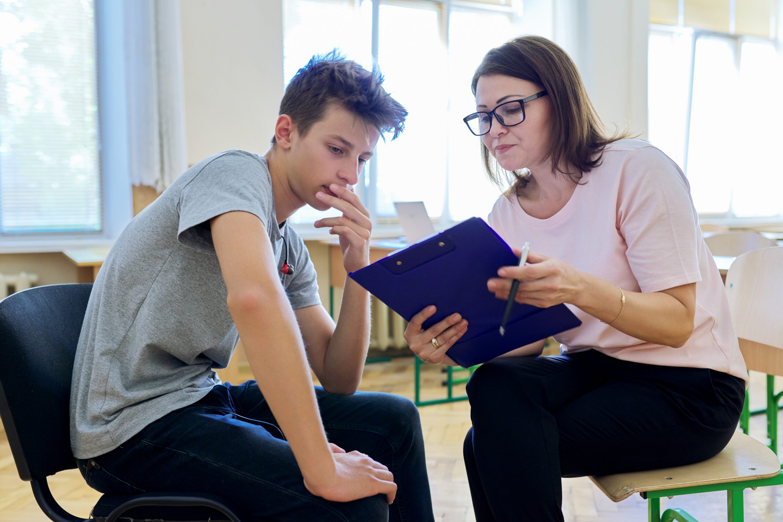 Woman school psychologist talking and helping student male teenager Acceptance Path Counseling Therapist helping a client understand difficulty starting everyday responsibilities